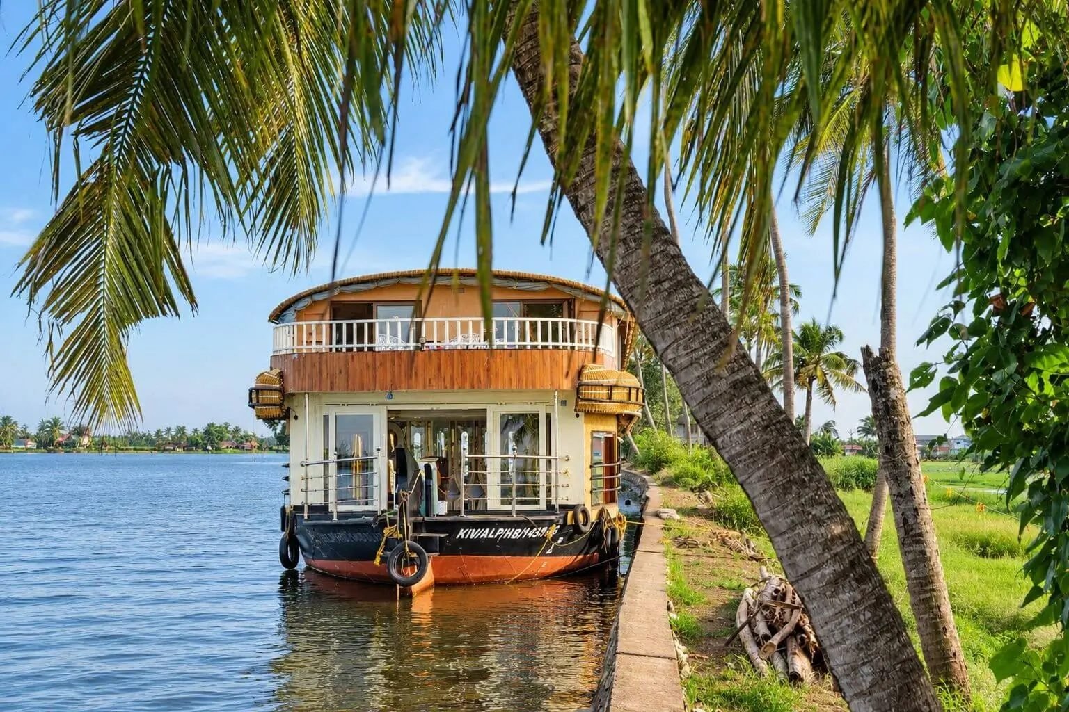 Kodupunna Kuteeram deluxe 5 bedroom houseboat moored under leaning coconut palms