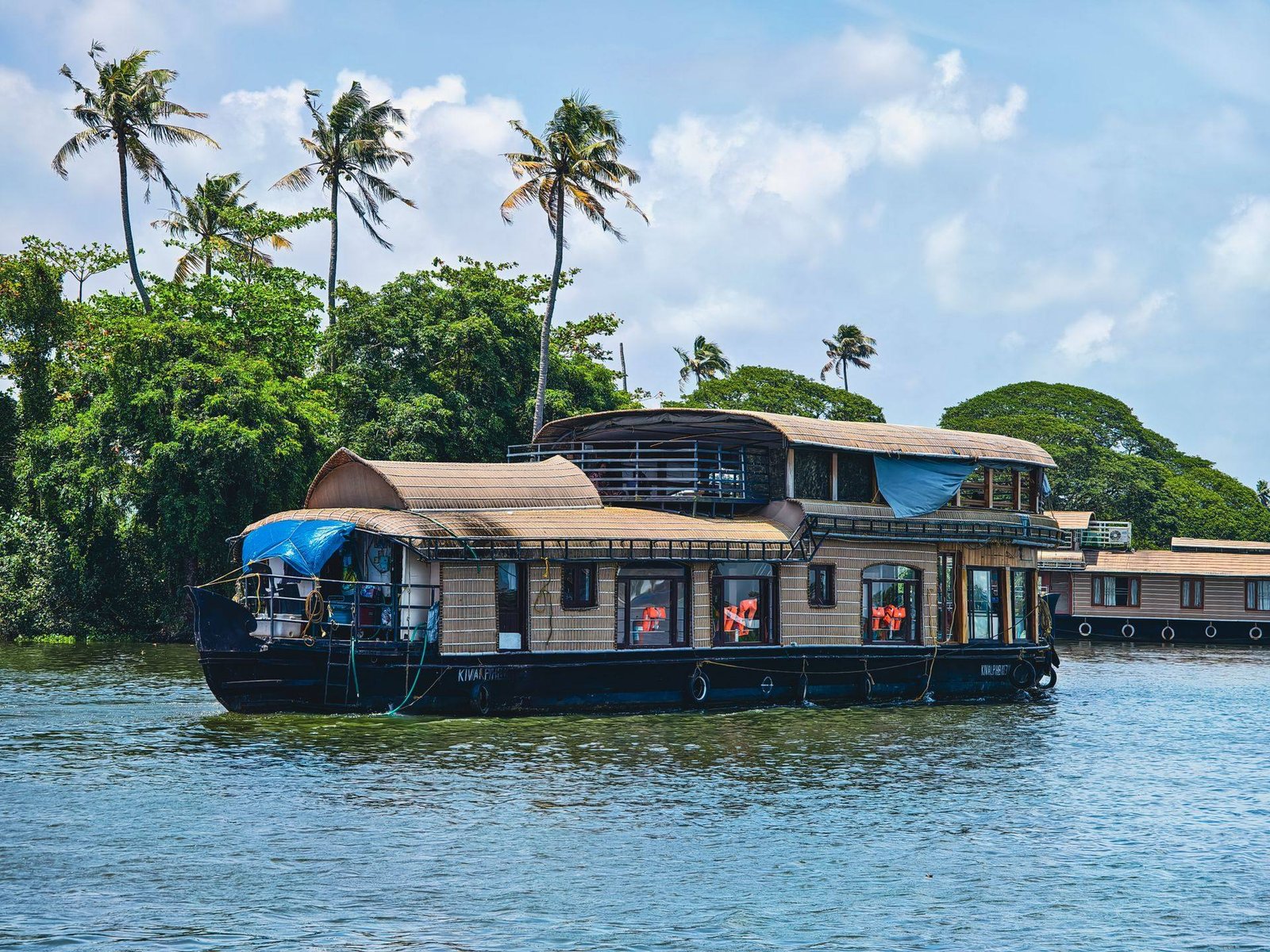 Vembanad Vista premium AC houseboat cruising the Kerala backwaters under blue sky