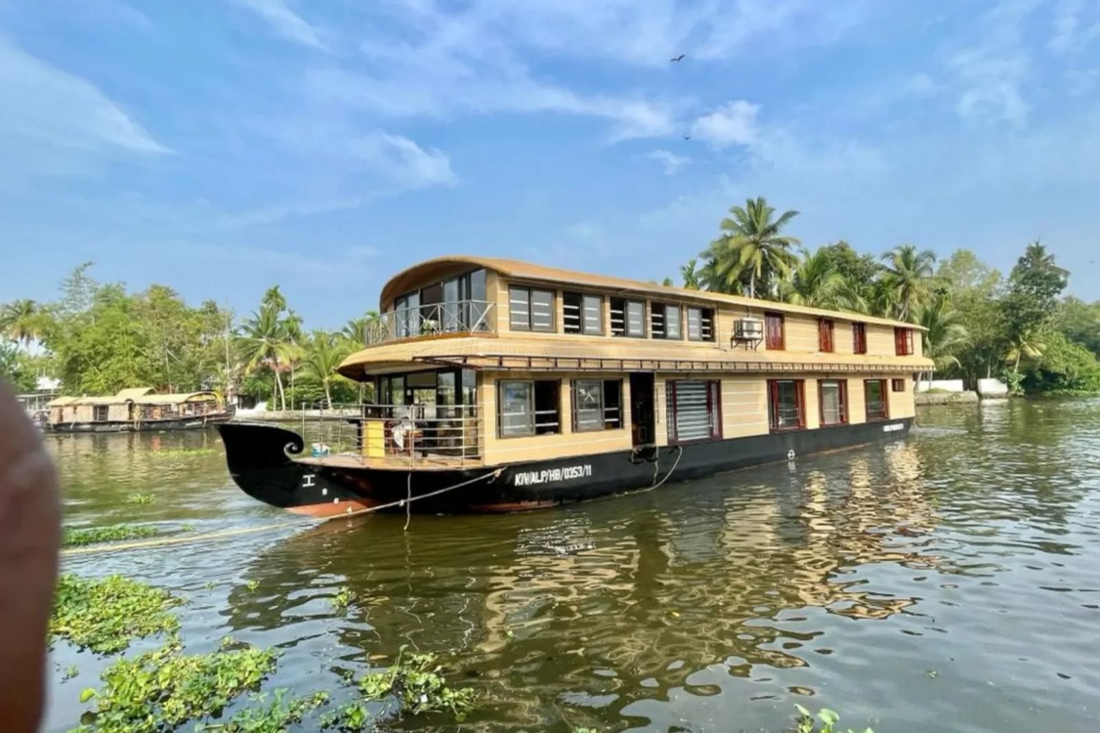 Kuttamangalam Kettu deluxe 6 bedroom houseboat moored by palm trees