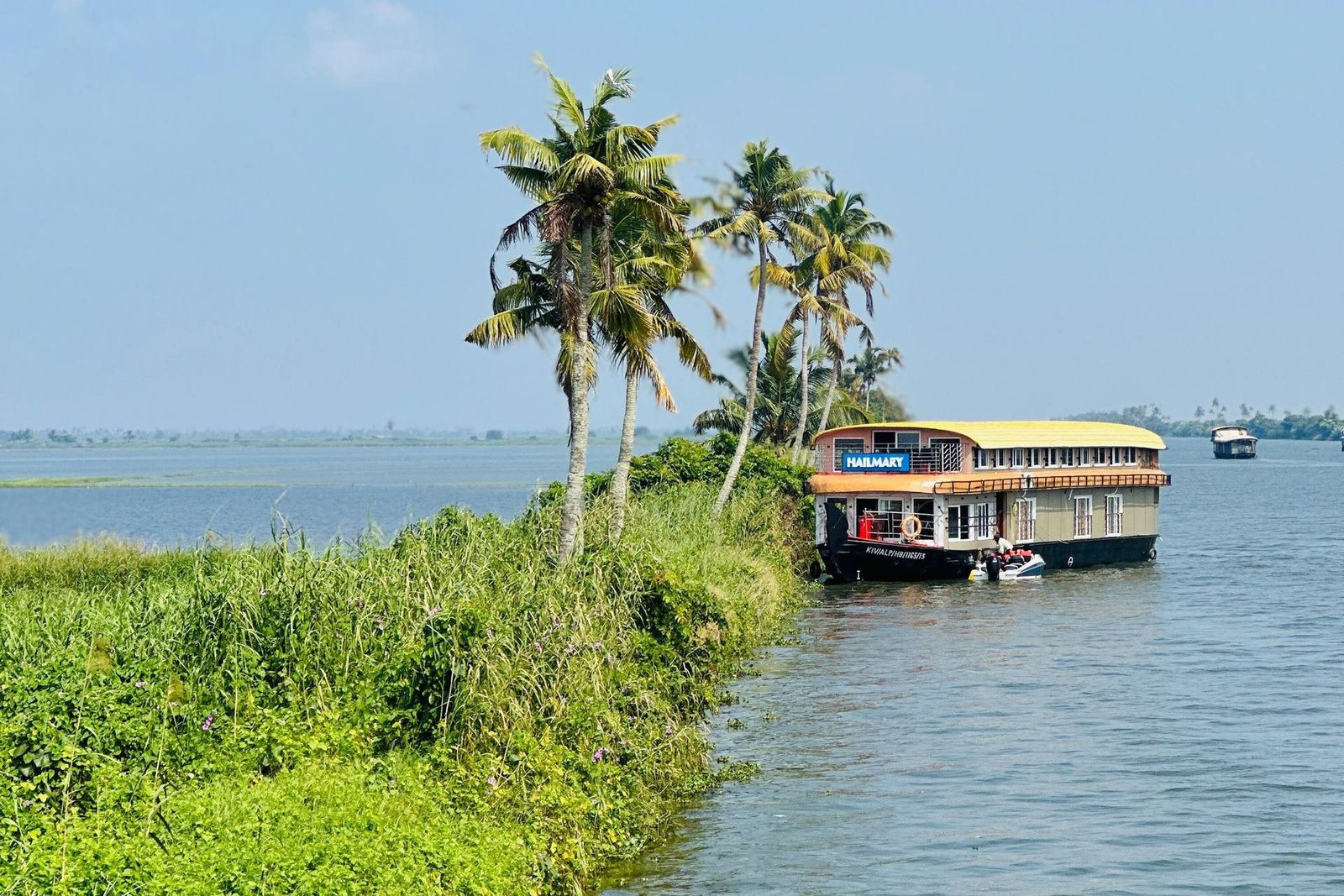 Pathiramanal Sovereign ultra luxury 3 bedroom houseboat moored by palms on Vembanad Lake