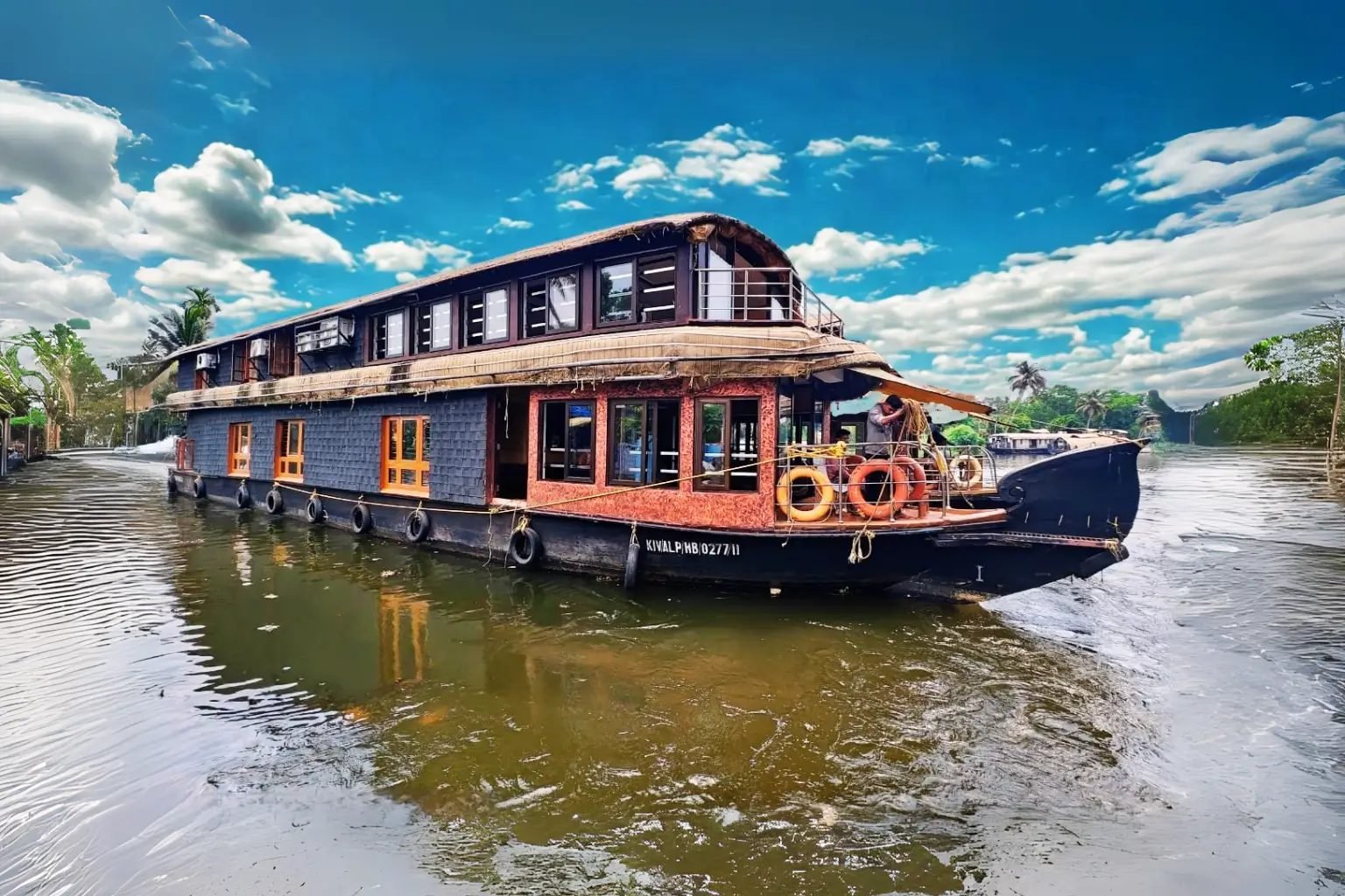Kayalpuram Kovilakam premium 5 bedroom houseboat cruising under a bright blue sky